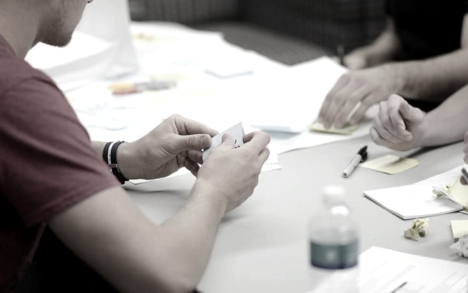 A team working through notes and sticky notes around a table